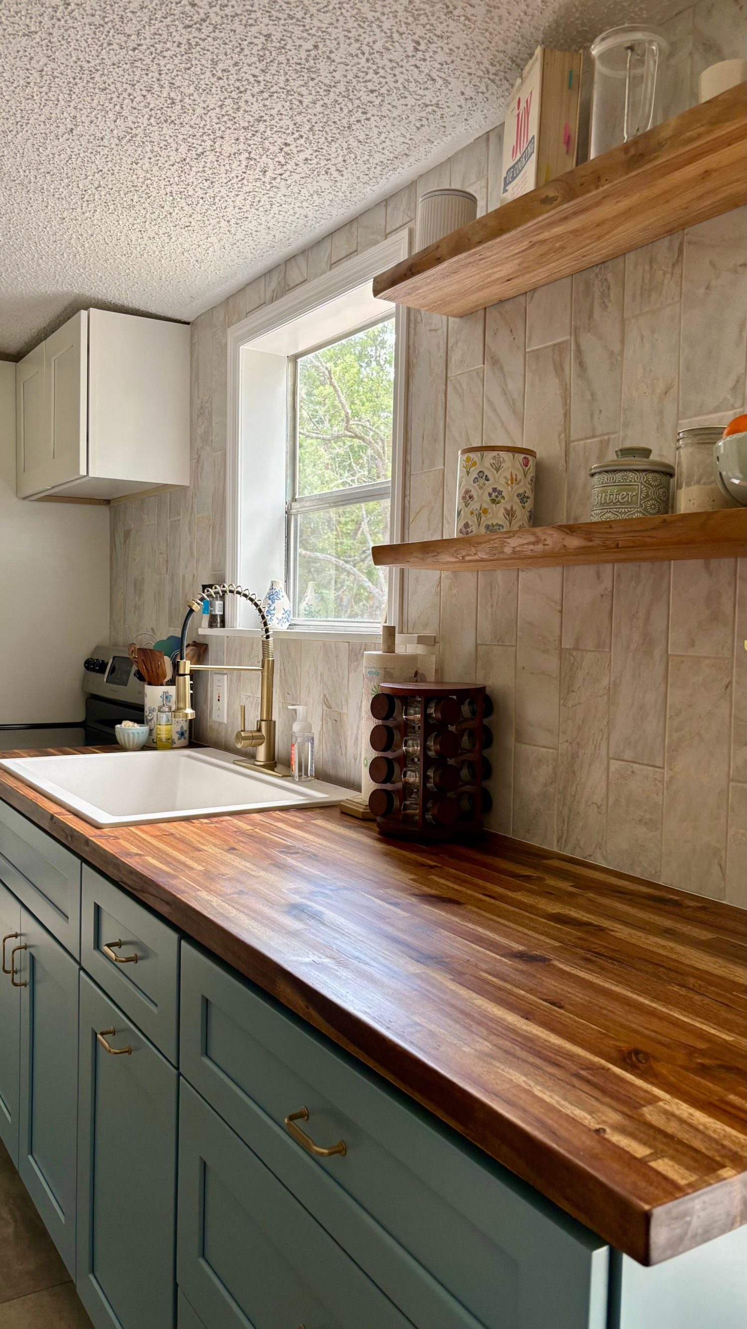 Kitchen remodel with Arctic blue shaker cabinets, butcher-block countertop and floating wood shelves