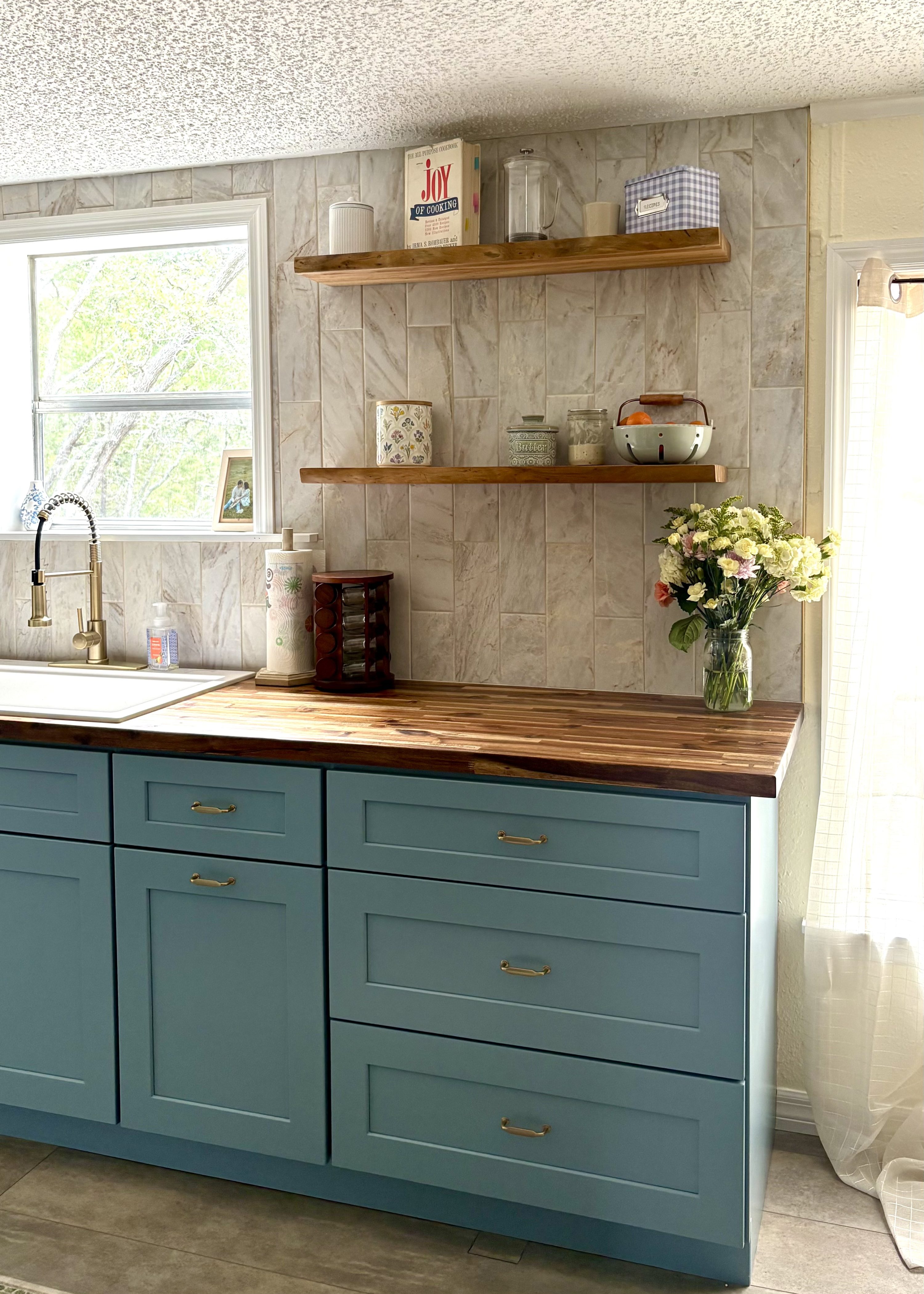 Kitchen remodel with Arctic blue shaker cabinets, butcher-block countertop and floating wood shelves