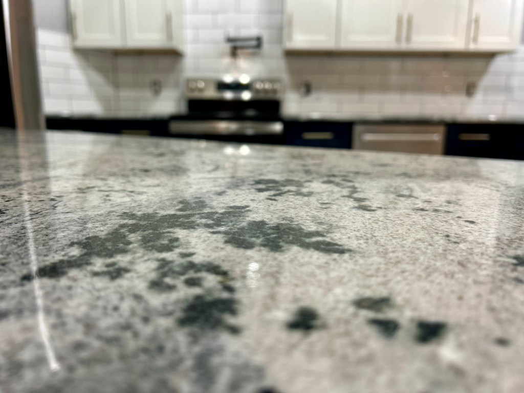 Granite countertop with white upper cabinets and dark lower cabinets in Homosassa, Florida