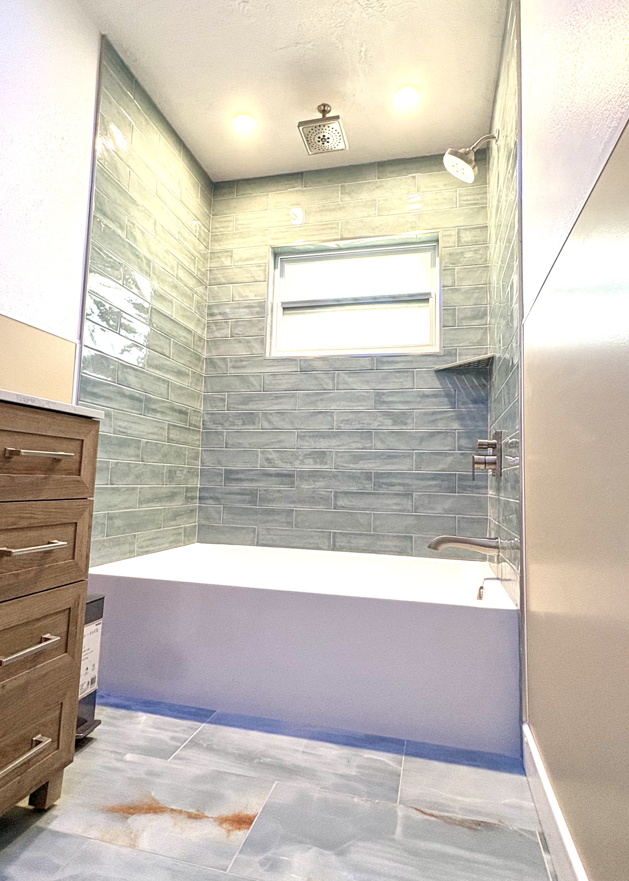 Bathtub and shower remodel with blue-gray horizontal wall tile