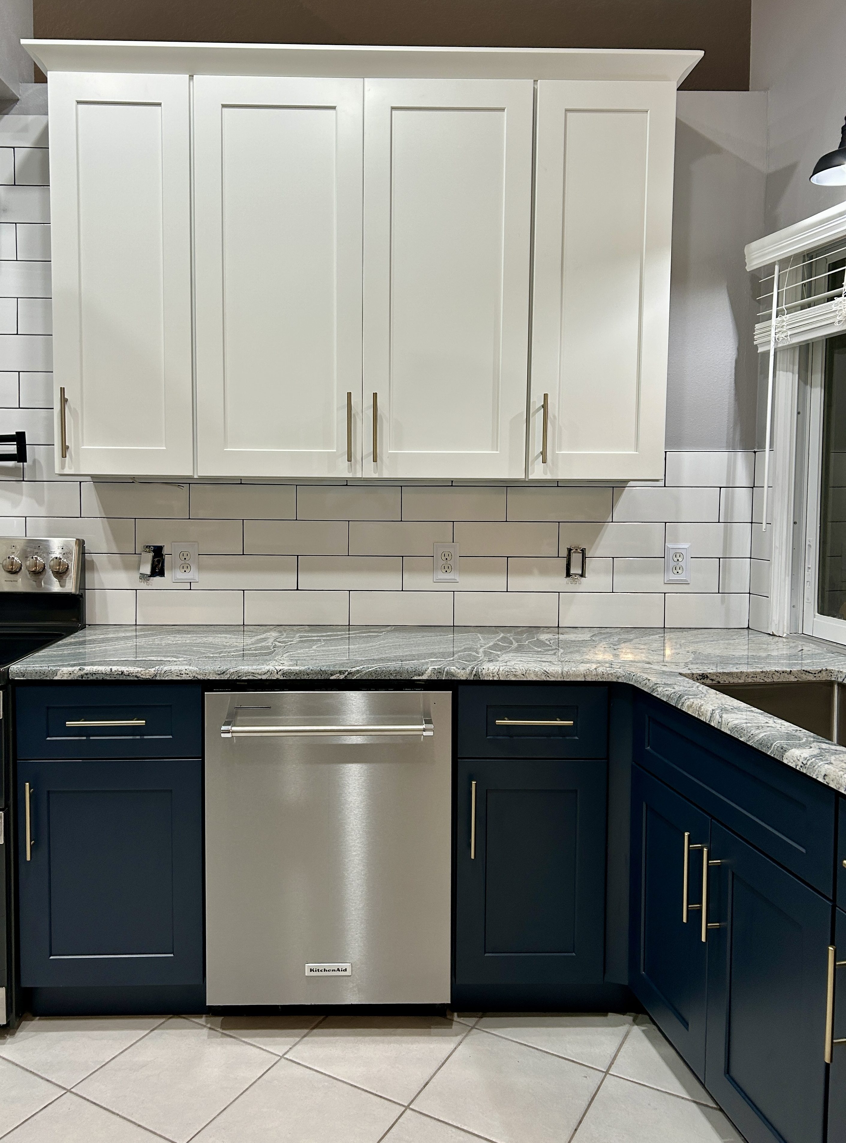 Kitchen remodel with white upper cabinets, blue lower cabinets, granite countertops and subway tile in Homosassa, Florida